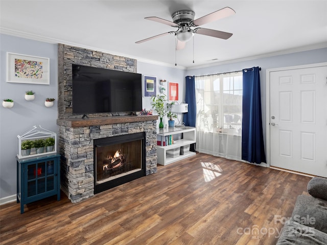 living area with a fireplace, crown molding, and wood finished floors