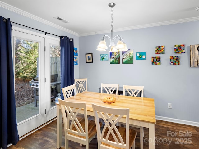 dining room with crown molding, visible vents, dark wood finished floors, and a notable chandelier