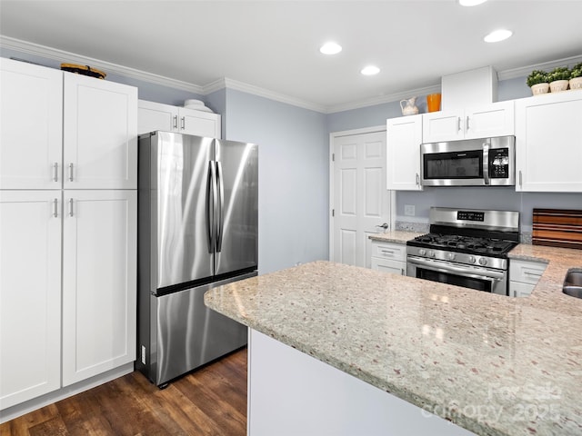 kitchen featuring light stone counters, white cabinetry, ornamental molding, appliances with stainless steel finishes, and dark wood finished floors