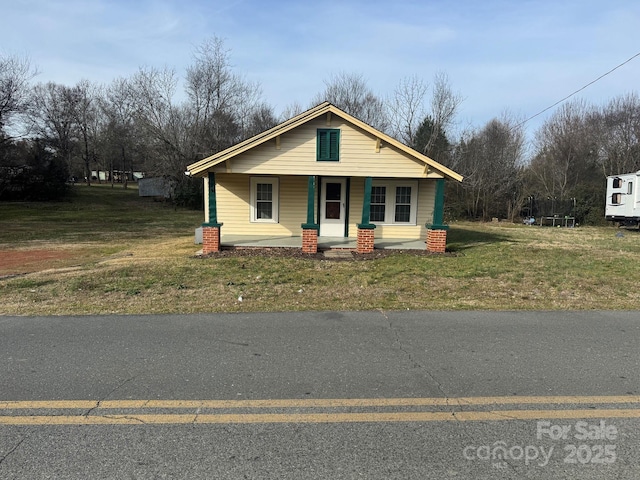 view of front of property with a porch and a front lawn