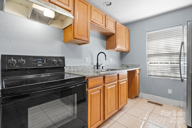 kitchen featuring black range with electric stovetop, a sink, visible vents, ventilation hood, and freestanding refrigerator