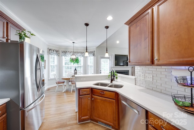 2050 Sunswept Ln, York, SC 29745 - kitchen featuring appliances with stainless steel finishes, a sink, tasteful backsplash, a peninsula, and light wood-style floors