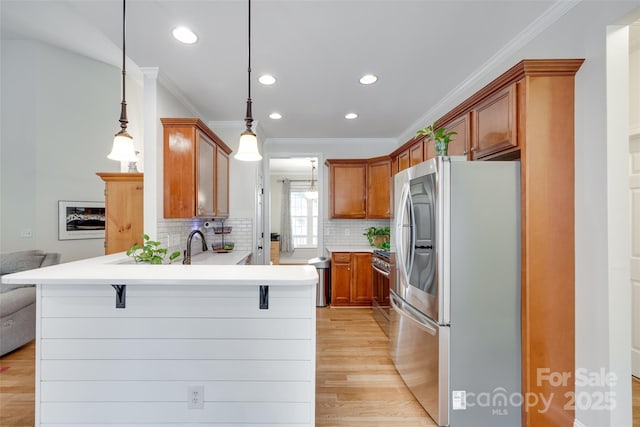 2050 Sunswept Ln, York, SC 29745 - kitchen featuring appliances with stainless steel finishes, ornamental molding, a peninsula, tasteful backsplash, and light wood-type flooring