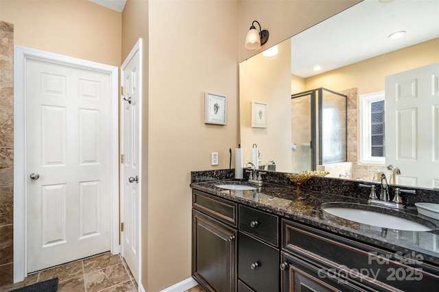 full bathroom featuring a shower stall, double vanity, baseboards, and a sink