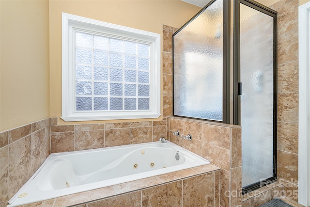 bathroom featuring a tub with jets and a stall shower