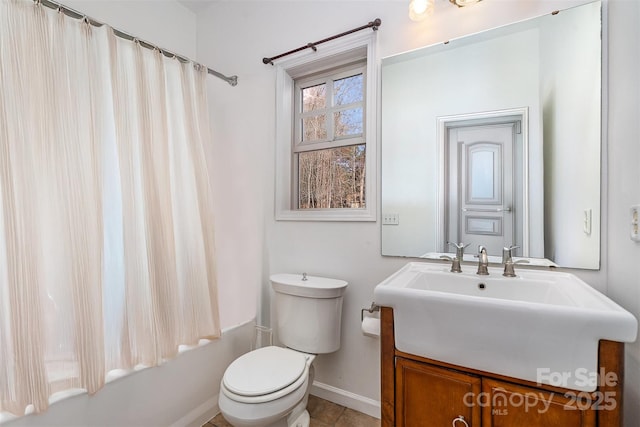 bathroom with baseboards, toilet, vanity, and shower / bath combination with curtain