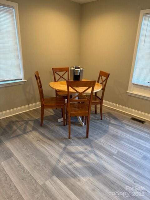 dining area with visible vents, baseboards, and wood finished floors