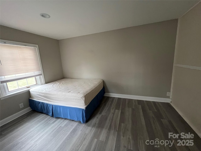 unfurnished bedroom featuring baseboards and wood finished floors