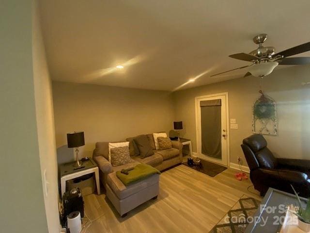 living room featuring light wood-style flooring and a ceiling fan