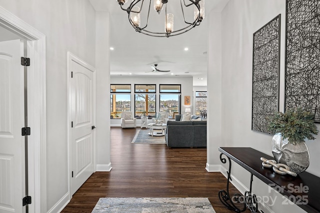 hall with recessed lighting, a notable chandelier, baseboards, and wood finished floors