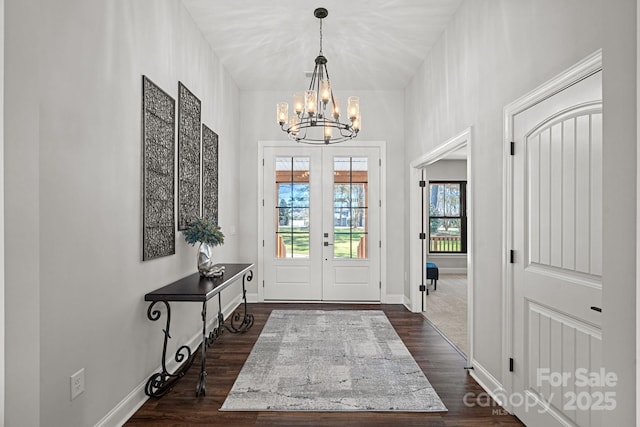 entryway with baseboards, a chandelier, dark wood-style flooring, and french doors