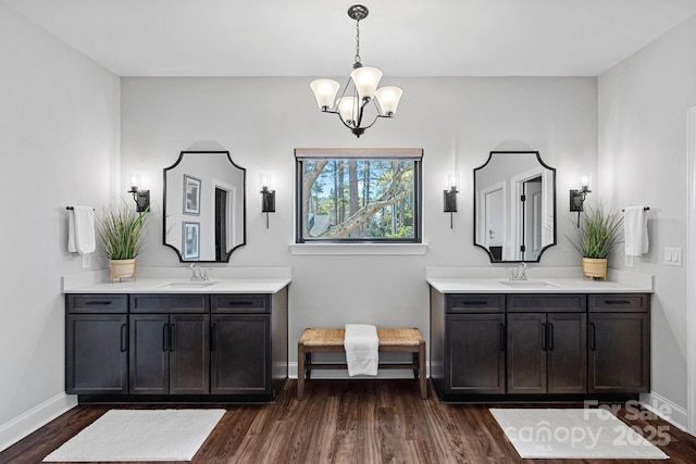 bathroom featuring two vanities, a sink, and wood finished floors