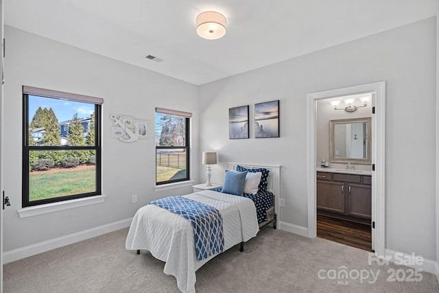 bedroom featuring carpet, a sink, visible vents, and baseboards