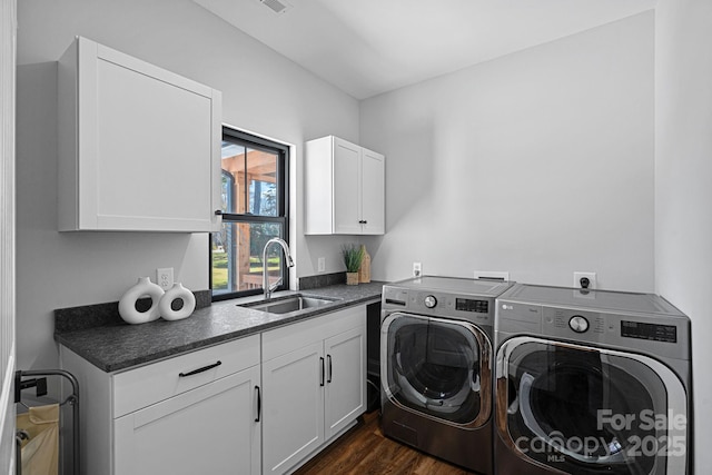 washroom with dark wood-style flooring, a sink, visible vents, washer and dryer, and cabinet space