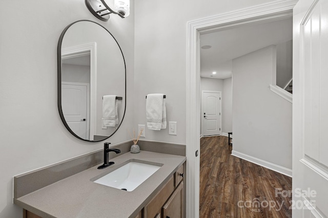 bathroom featuring vanity, baseboards, and wood finished floors