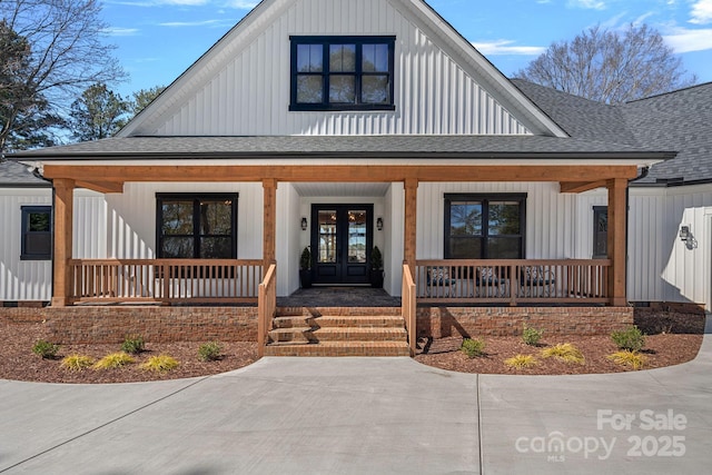 modern farmhouse style home featuring covered porch, roof with shingles, board and batten siding, and french doors