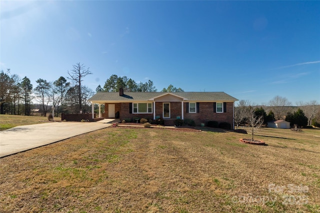 ranch-style home featuring brick siding, driveway, a front yard, and a carport