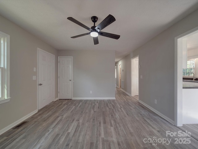 spare room featuring visible vents, baseboards, and wood finished floors