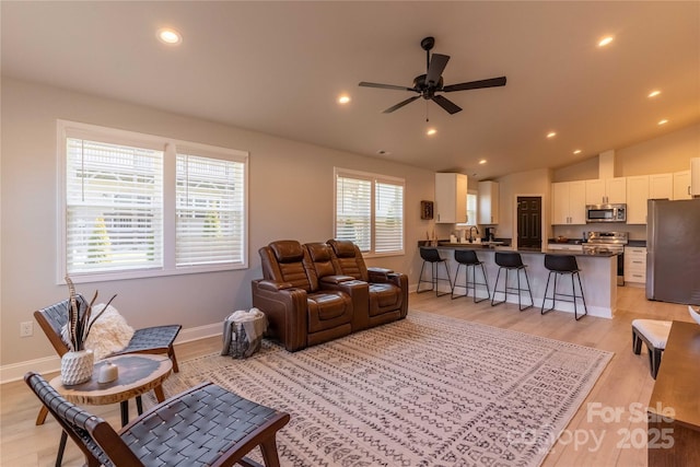 living room with lofted ceiling, ceiling fan, recessed lighting, baseboards, and light wood-type flooring