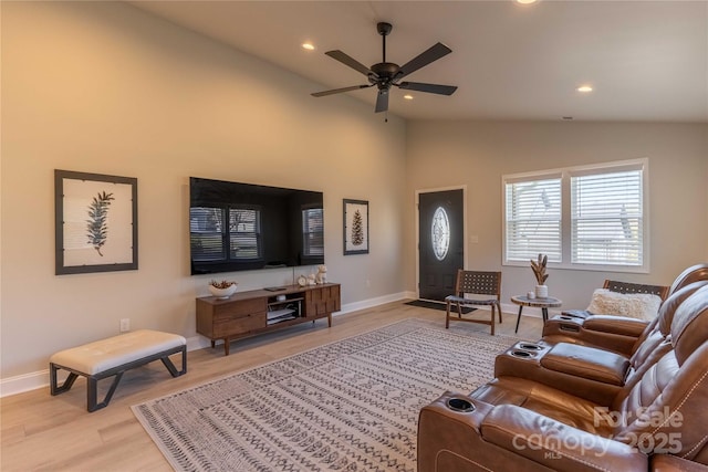 living area featuring baseboards, lofted ceiling, ceiling fan, light wood-style floors, and recessed lighting