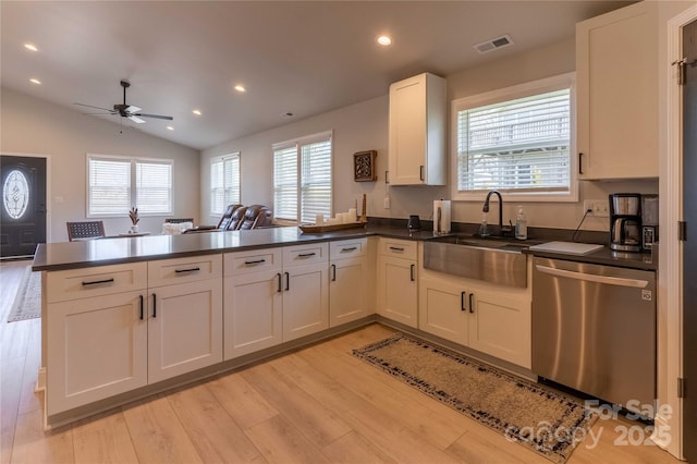 kitchen featuring dark countertops, visible vents, a sink, and stainless steel dishwasher