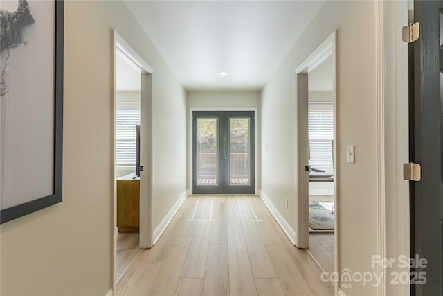 foyer with light wood-type flooring, french doors, and baseboards