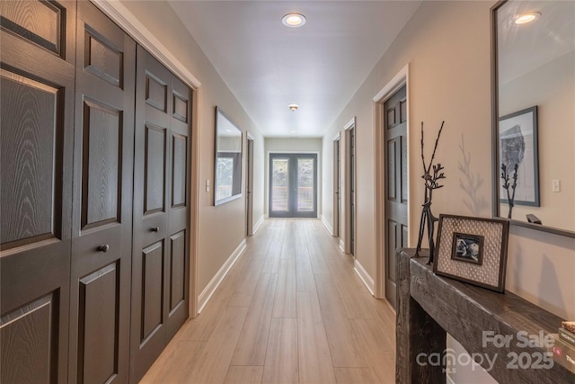 corridor with french doors, recessed lighting, light wood-style flooring, and baseboards