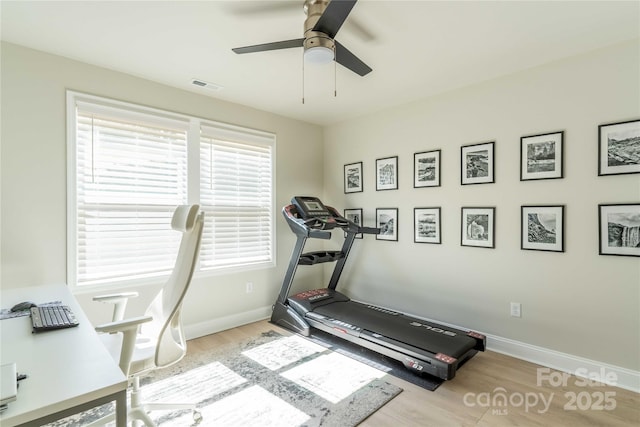 exercise room featuring a ceiling fan, wood finished floors, visible vents, and baseboards