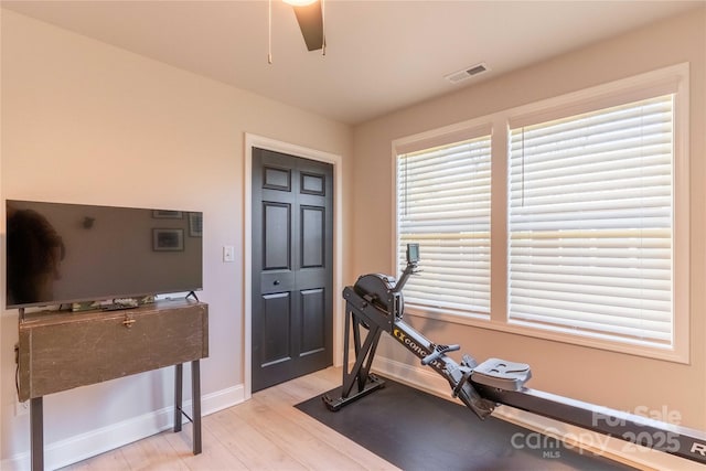 workout room with ceiling fan, wood finished floors, visible vents, and baseboards