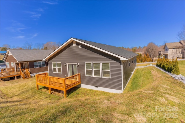 rear view of property with crawl space, a deck, and a yard