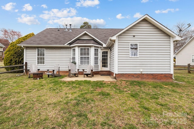 back of property with an outdoor fire pit, fence, and a lawn