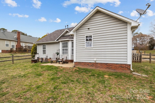 back of property with a yard, a patio area, and fence