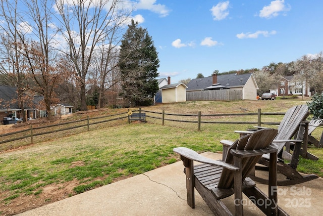 view of yard with an outbuilding, a patio, a shed, and fence