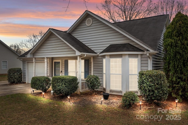 bungalow-style house featuring a garage, driveway, and roof with shingles