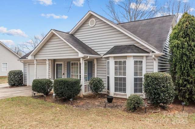 bungalow-style home featuring a garage, concrete driveway, and a shingled roof