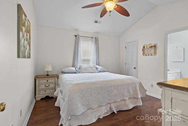 bedroom with lofted ceiling, dark wood-style flooring, visible vents, and baseboards