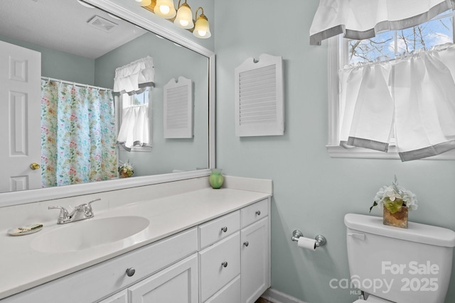 full bathroom featuring toilet, visible vents, and vanity