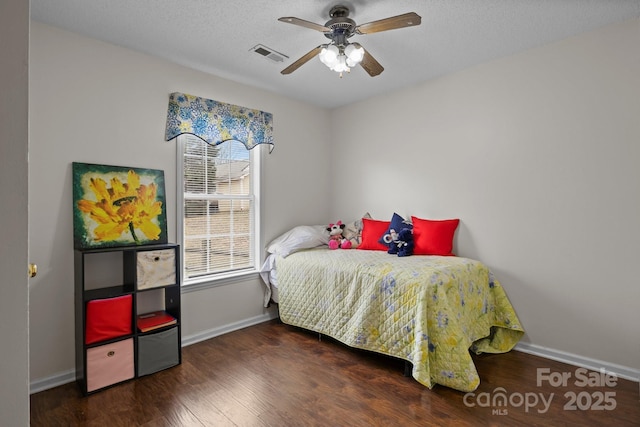 bedroom featuring a textured ceiling, wood finished floors, visible vents, and baseboards