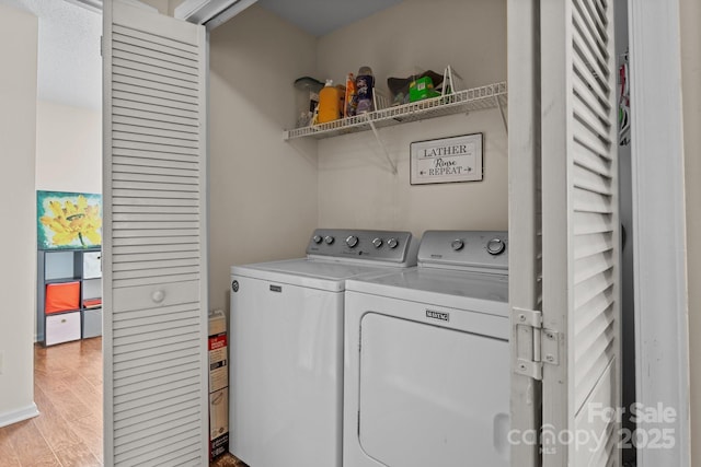 clothes washing area featuring laundry area, separate washer and dryer, and light wood-style floors