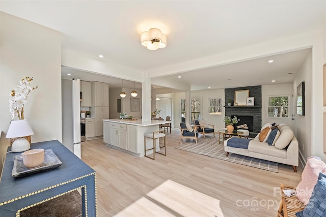 interior space with light wood finished floors, a fireplace, and recessed lighting