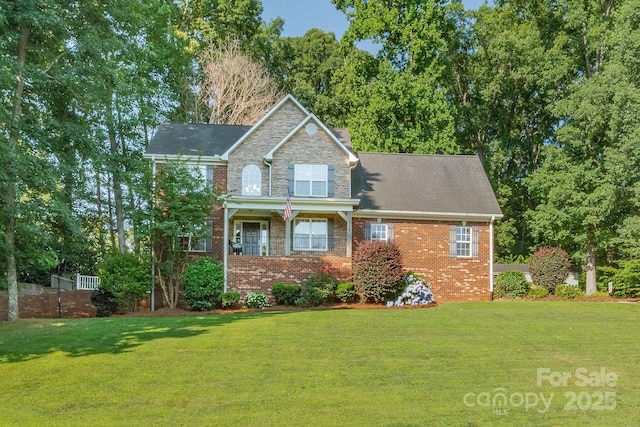 view of front facade with stone siding, a front lawn, and brick siding