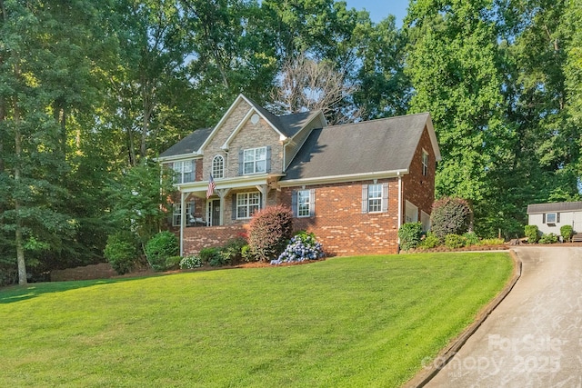 view of front facade with stone siding, brick siding, and a front yard