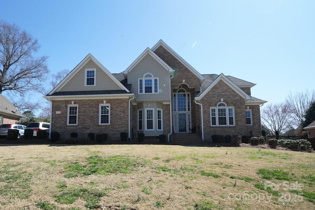 traditional-style house with a front yard and brick siding