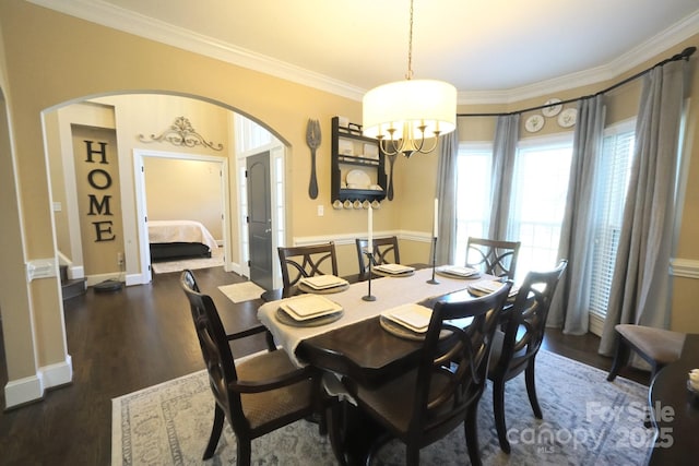 dining area featuring stairway, crown molding, arched walkways, and wood finished floors