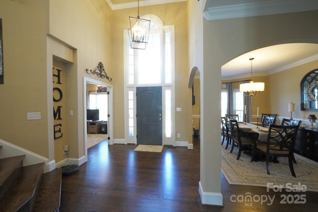 foyer featuring ornamental molding, a notable chandelier, and wood finished floors