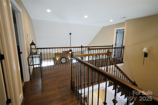 hall with an upstairs landing, visible vents, wood finished floors, and recessed lighting