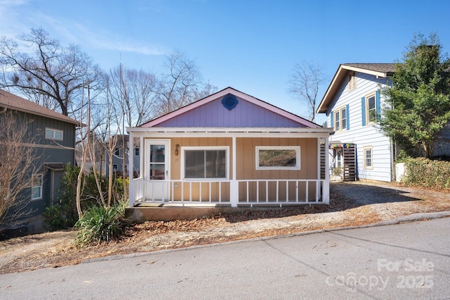 bungalow-style home with covered porch and board and batten siding