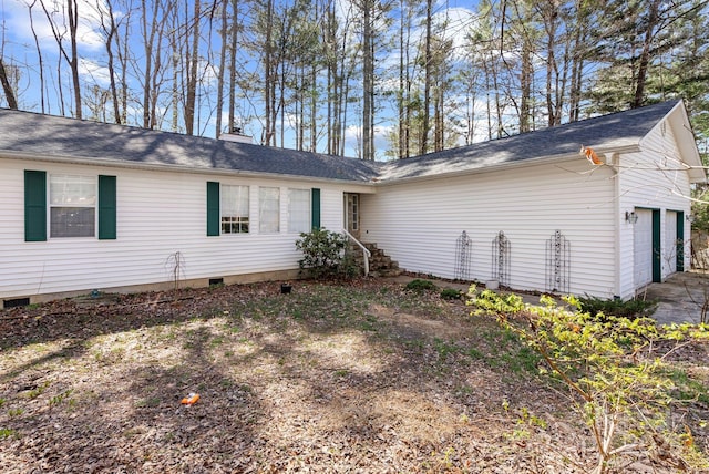 view of property exterior with a garage, crawl space, and a chimney