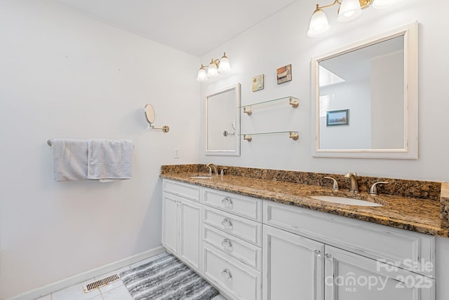 bathroom with visible vents, a sink, baseboards, and double vanity