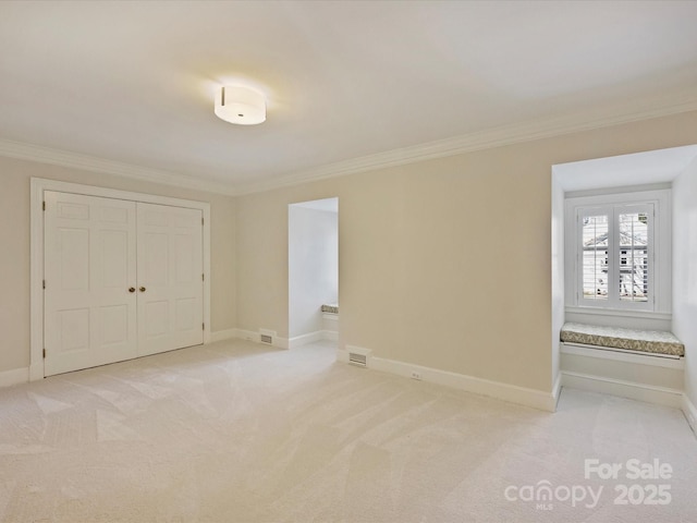 unfurnished bedroom featuring ornamental molding, light carpet, visible vents, and baseboards